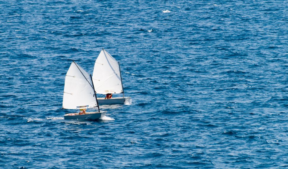 Small racing sailboat in class "optimist". Training and practice.